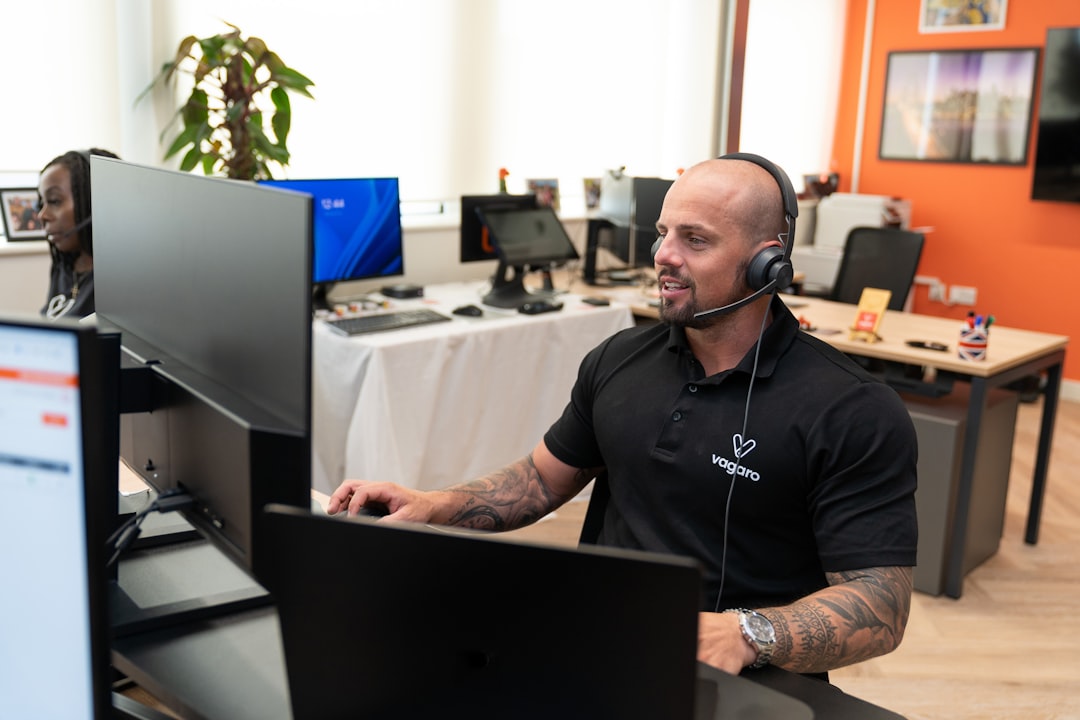 A customer support representative at Vagaro is assisting a client through a headset, offering support in an office.