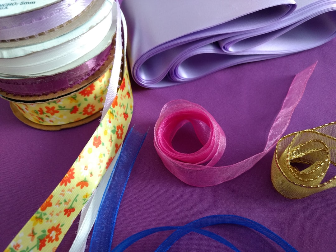 A stack of ribbons, and some others on a purple background; Plain colors and floral a pattern, great for crafting, sewing, etc.
Cintas estivadas, y otras sueltas, de diversos materiales, apropiados para manualidades y costura. Colores enteros y también floreada.